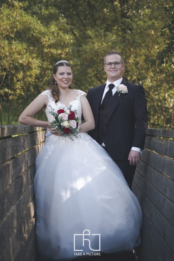 Ein Brautpaar beim Portraitshooting mit Brautstrauß