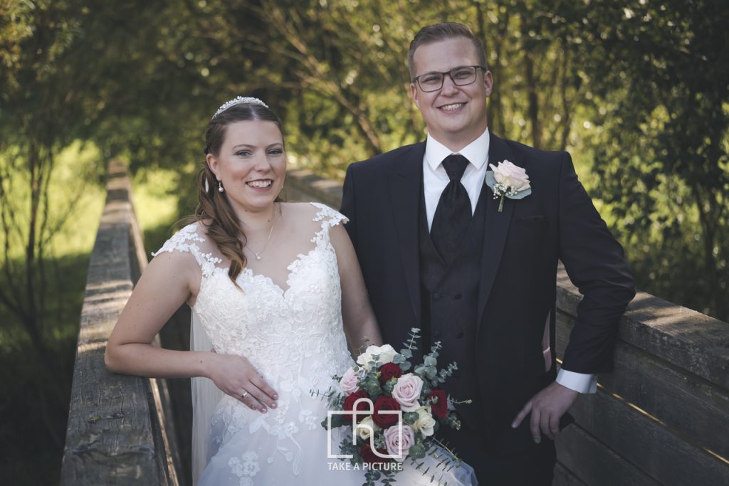 Brautpaarfoto einer Hochzeit in romatischer Atmosphäre in der Natur auf einer Brücke